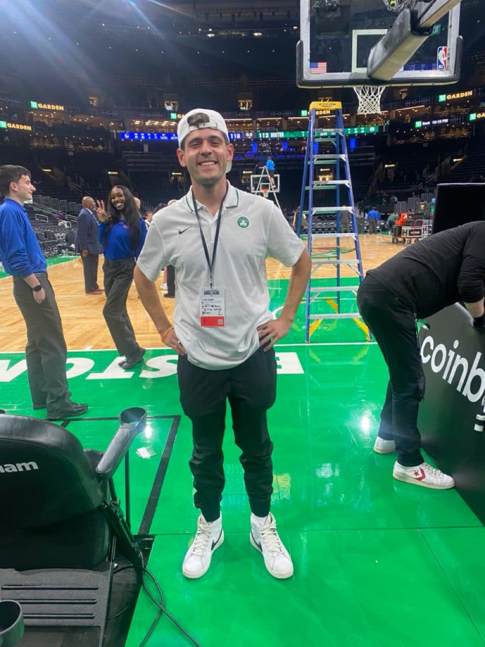 Griffin Whitman courtside on the parquet at TD Garden with his credential
